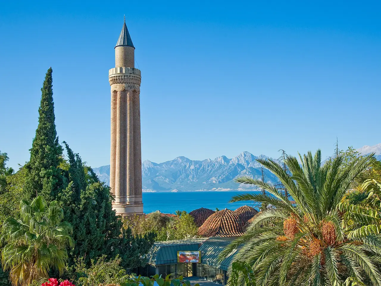 The fluted Yivli Minaret in Antalya's old town with the sea and snow-capped Taurus mountains behind