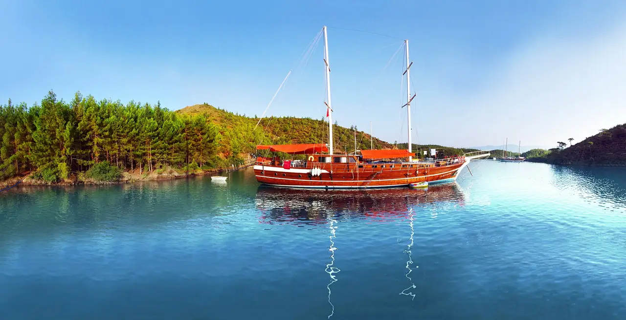 Göcek yakınında çamlarla çevrili sakin bir koyda demirli kırmızı bir gulet