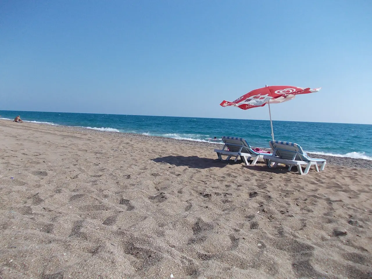Sandy beach with a sun lounger and parasol at Titreyengöl, Side