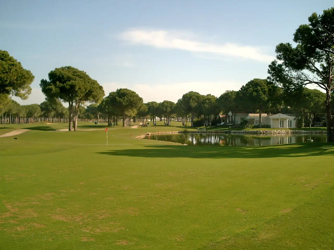 Belek'te bir golf sahasında çam ağaçlı fairway ve gölet