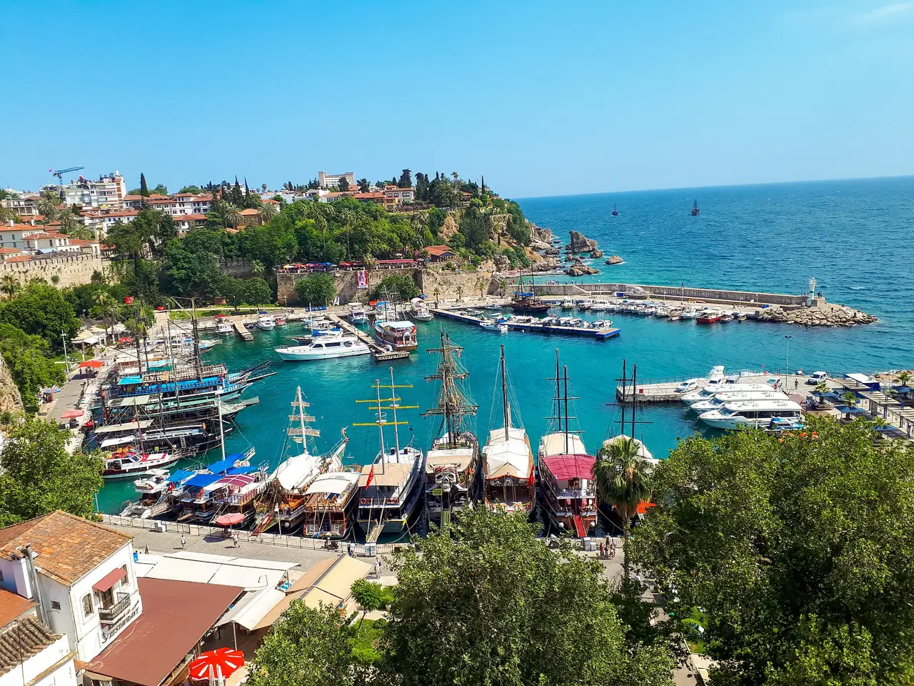 De oude haven van Antalya onder de kliffen van Kaleiçi met boten en turquoise water