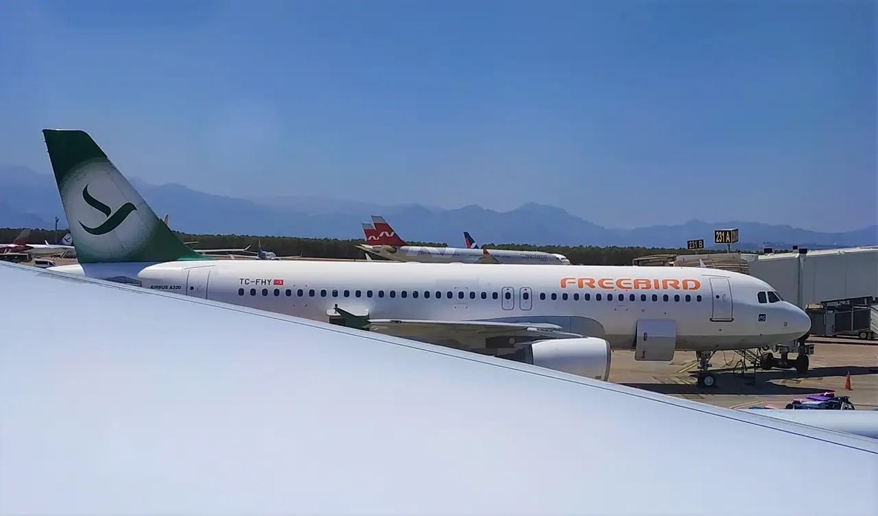 Arkasında Toros Dağları ile Antalya Havalimanı'nda bir uçak